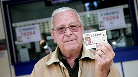 Un hombre posa hoy en Valencia con un décimo del número 70.624, que ha sido premiado con un quinto premio en el sorteo de Navidad, dotado con 60.000? a la serie. EFE/Manuel Bruque