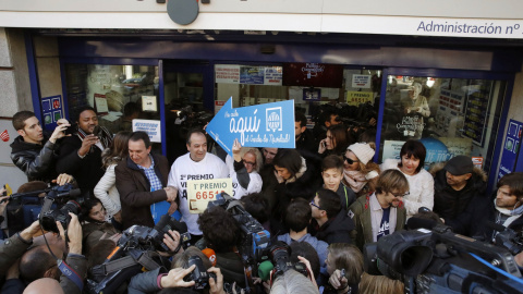 Decenas de periodistas se aglomeran a las puertas de la administración situada en el Paseo de la Esperanza, número 4, en Madrid, donde ha sido vendido el número 66.513, agraciado con el Gordo de Navidad.  EFE/Juan Carlos Hidalgo