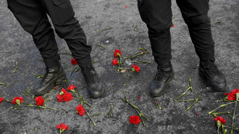 La gente coloca flores frente a los policías turcos que permanecen de guardia cerca de la discoteca Reina de Estambul donde se produjo el atentado. REUTERS / Umit Bektas