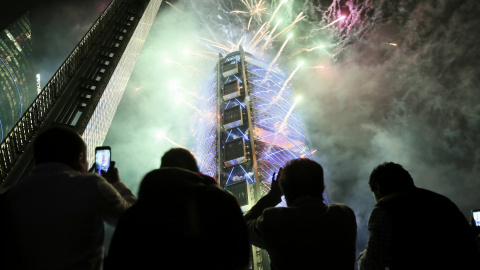 El público observa el edificio BBVA Bancomer envuelto en fuegos artificiales anoche, durante su inauguración en Ciudad de México.EFE/José Méndez