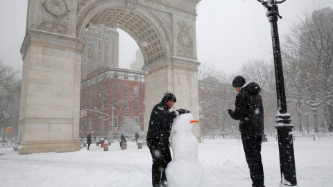 Dos personas construyen un muñeco de nieve en Manhattan. REUTERS/Andrew Kelly