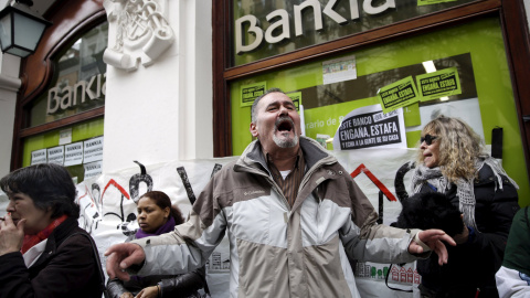 Activistas gritan durante una protesta contra los desahucios en una sucursal bancaria de Bankia en Madrid. REUTERS/Andrea Comas