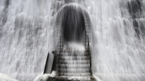 Una cascada de agua por el desbordamiento de la esculsa de Diemeltal cae sobre una puerta en el muro en Diemelsee, Alemania. EFE/Uwe Zucchi