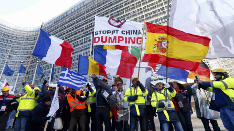 Los trabajadores europeos de acero sostienen banderas nacionales a medida que toman parte en una manifestación en el centro de Bruselas como protesta contra el dumping chino. REUTERS