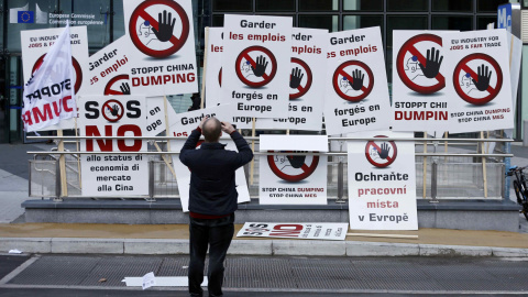 Un manifestante toma imágenes de los carteles que los trabajadores europeos de acero utilizan como protesta en el centro de Bruselas. REUTERS