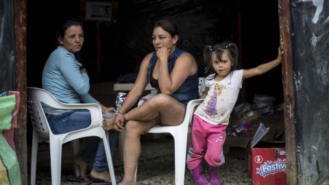 Dos guerrilleras de las FARC descansan junto a una niña en la zona veredal de La Elvira, en el Cauca, Colombia.- JAIRO VARGAS