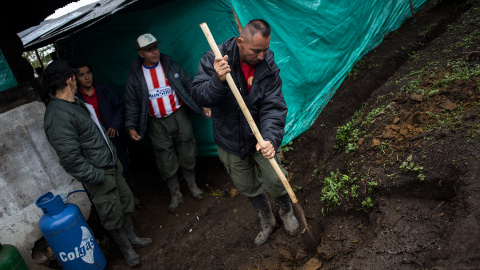 Varios guerrilleros de las FARC retiran el barro producido por la lluvia en el campamento de transición para la guerrilla en La Fila, en la región de Tolima, Colombia.- JAIRO VARGAS