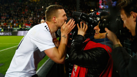 El jugador Lukas Podolski besa a un cámara de televisión tras su aparición final en el partido de la selección alemana contra la inglesa. REUTERS