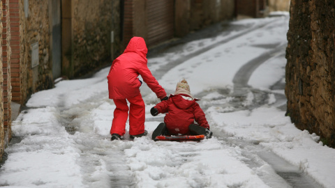 Dos niños en una calle de Vilanova de Prades tras la nevada caída en la zona. EFE/Jaume Sellart