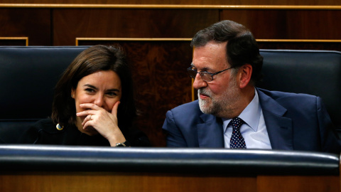 El presidente del Gobierno en funciones, Mariano Rajoy, junto a la vicepresidenta en funciones, Soraya Sáenz de Santamaría, durante la primera jornada de la sesión de investidura del secretario general del PSOE, Pedro Sánchez, esta tarde en