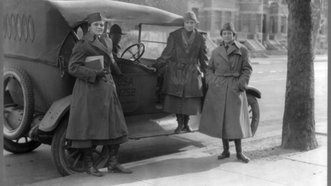 Los miembros del Cuerpo de Radio de la Mujer de pie junto a un coche del ejército.- REUTERS