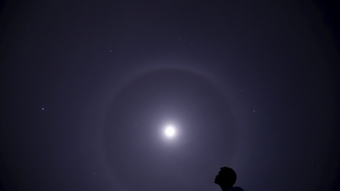 Un hombre mira un halo lunar sobre el cielo de Katmandú. REUTERS/Navesh Chitrakar