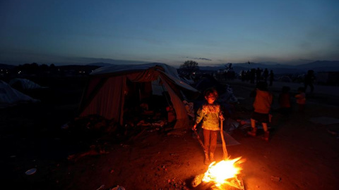 Varios refugiados encienden un fuego en un campo de la frontera entre Grecia y Macedonia en Idomeni, Grecia. EFE