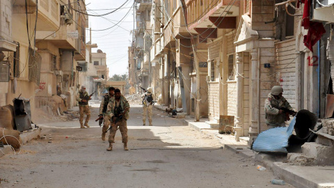 Soldados leales al presidente sirio Bashar al-Assad caminan por las calles de Palmira, tras expulsar a los militantes del Estado Islámico. REUTERS/SANA