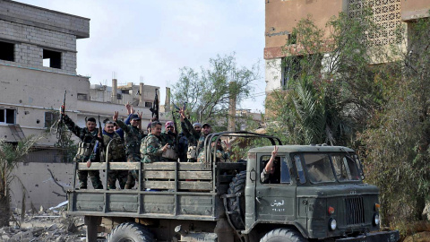 Un camion con tropas leales al presidente sirio Bashar al-Assad, hacen el signo de la victoria al pasar por las calles de Palmira tras expulsar al Estado Islámico. REUTERS/SANA