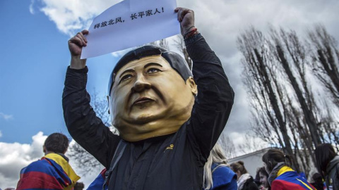 Un manifestante que lleva puesta una cabeza con la imagen del presidente chino, Xi Jinping, participa en una protesta por la visita del mandatario en Praga. EFE/Filip Singer