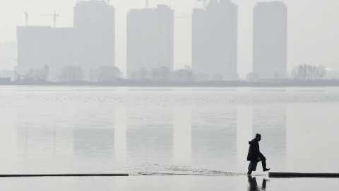 Un hombre camina por un lago artificial en Taiyuan, provincia de Shanxi, China. REUTERS/Jon Woo