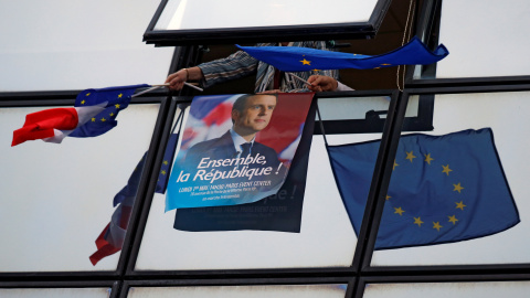 Uno de los carteles de campaña de Emmanuel Macron rodeado de banderas de la Unión Europea.- REUTERS