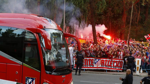 Cientos de aficionados del Atlético, algunos con bengalas, al paso del autobús de su equipo. /EFE