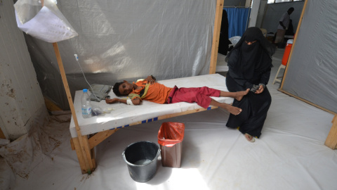 Una mujer se sienta junto a su hijo enfermo de cólera en un hospital de la ciudad de Hodeidah, Yemen.- REUTERS / Abduljabbar Zeyad