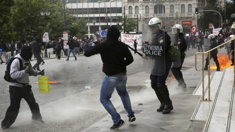 Varios activistas se enfrentan a la policía antidisturbios mientras participan en una manifestación durante la huelga general de 24 horas en Atenas (Grecia).EFE/Alexandros Vlachos