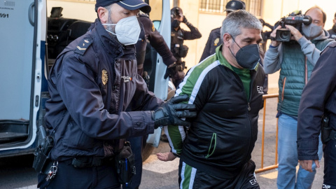 Un policía escolta al acusado Bernardo Montoya (d) durante su traslado a la Audiencia Provincial de Huelva, donde este lunes ha comenzado su juicio por agredir sexualmente y asesinar a Laura Luelmo, la profesora zamorana de 26 años, ocurrid