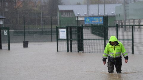 Un operario del Ayuntamiento de Arriondas (Asturias) trata de caminar por una calle completamente inundada este miércoles.