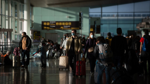 Varios pasajeros con maletas en el aeropuerto de El Prat, el 19 de noviembre de 2021, en Barcelona.