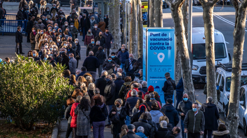 Personas hacen cola frente al centro de vacunación instalado en Barcelona antes de recibir la dosis de refuerzo de la vacuna contra el coronavirus, a 15 de diciembre de 2021.