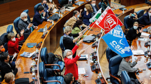 Diputados con banderas sindicales durante una sesión plenaria en la Asamblea de Madrid, a 22 de diciembre de 2021, en Madrid.