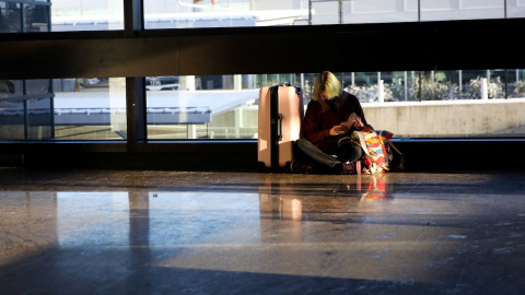 Un viajero espera un vuelo retrasado después de que decenas fueran cancelados o retrasados ​​en el Aeropuerto Internacional Seattle-Tacoma, a 27 de diciembre de 2021.