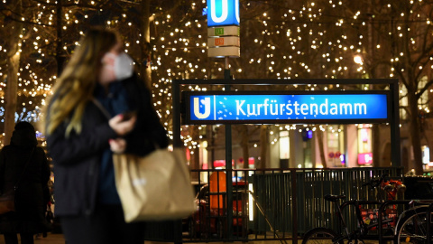 Una mujer que lleva una bolsa de compras pasea por la calle comercial Kurfuerstendamm de Berlín, en plena pandemia, a 23 de diciembre de 2021.