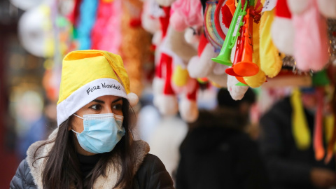 Una mujer con un gorro de Papa Noel y una mascarilla, el mismo día que entra en vigor la obligatoriedad de usar mascarilla en exteriores, a 24 de diciembre de 2021, en Madrid.