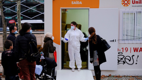 Un trabajador de la salud habla con las personas mientras esperan para hacerse las pruebas de la covid en Lisboa, Portugal, el 23 de diciembre de 2021.