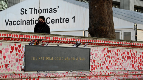 Una persona fuera del hospital St.Thomas con el National Memorial Wall en primer plano en Londres