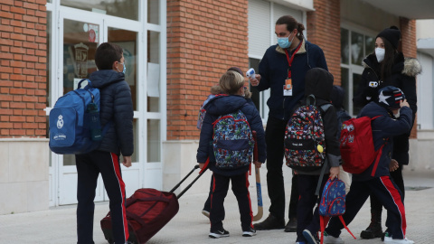 10/10/2022 Un trabajador toma la temperatura a un niño a su llegada al primer día de clase presencial tras la Navidad