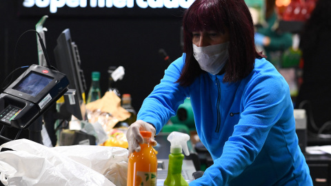 Una mujer durante su jornada laboral como trabajadora esencial en un supermercado de Madrid el 17 de marzo de 2020. GABRIEL BOUYS / AFP