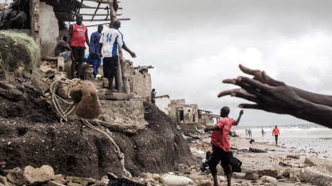 Un hombre repara un improvisado muro para proteger su casa antes de que llegue la próxima marea alta a Bargny (Senegal), el pasado 3 de septiembre de 2020.- JOHN WESSELS / AFP