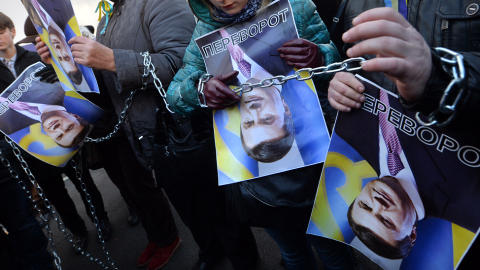 os manifestantes sostienen imágenes rotadas del presidente ucraniano Viktor Yanukovych y firmaron "Al revés" (en ucraniano la palabra también tiene otro significado: derrocamiento y revolución) durante la acción de protesta en el Ministerio