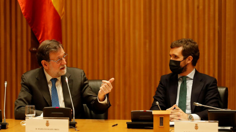 El ex presidente del gobierno Mariano Rajoy (i) y el líder del Partido Popular, Pablo Casado, durante el acto homenaje organizado este jueves por el GPP al que fuera diputado, Carlos Mantilla, en el Congreso de los Diputados en Madrid.