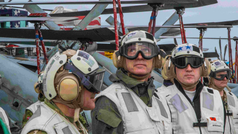 El secretario general de la OTAN, Jens Stoltenberg (C), observa un F-18 Super Hornet aterrizando en el portaaviones USS Harry S. Truman.