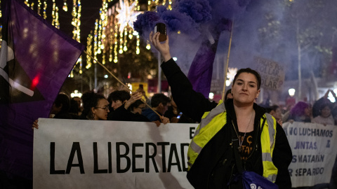 Una mujer con un bote de humo morado, durante una manifestación por el 25N en Barcelona.