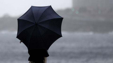 Una persona con paraguas se protege de la lluvia, en una imagen de archivo.