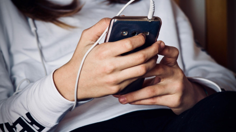 Imagen de una adolescente con un teléfono.