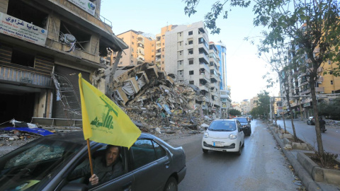 Ciudadanos ondean la bandera de Hizbulá mientras conducen por los suburbios del sur de Beirut, a 27 de noviembre de 2024.