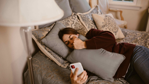  Una mujer en el sofá con su teléfono móvil.- RDNE Stock project.