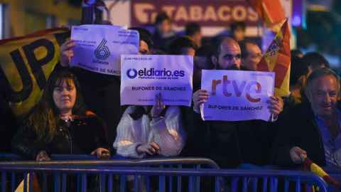  Tres personas muestran carteles en contra de algunos medios de comunicación, durante una manifestación contra la amnistía frente a la sede del PSOE en Ferraz. Gustavo Valiente / Europa Press