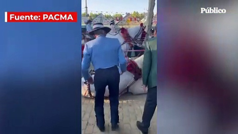 Dos hombres patean a un caballo agotado que se desplomó durante la Feria de Abril de Sevilla