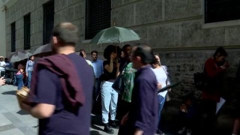 Reparten paraguas para combatir el calor en la cola del padrón del Ayuntamiento de Valencia