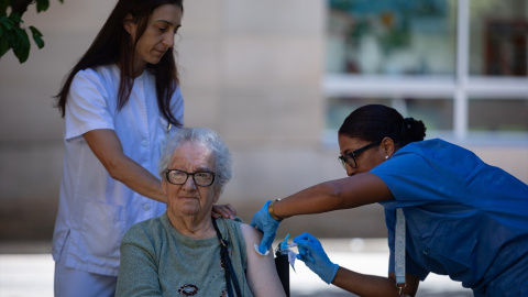 Personal sanitario vacuna a una mujer. Imagen de archivo.